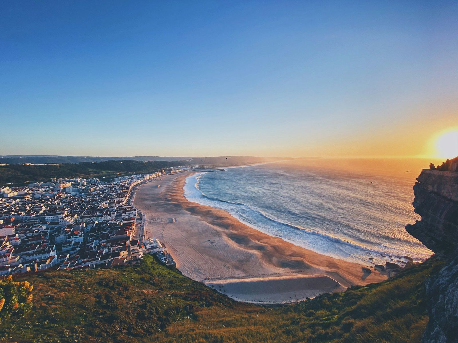 Het strand van Nazaré bij zonsondergang